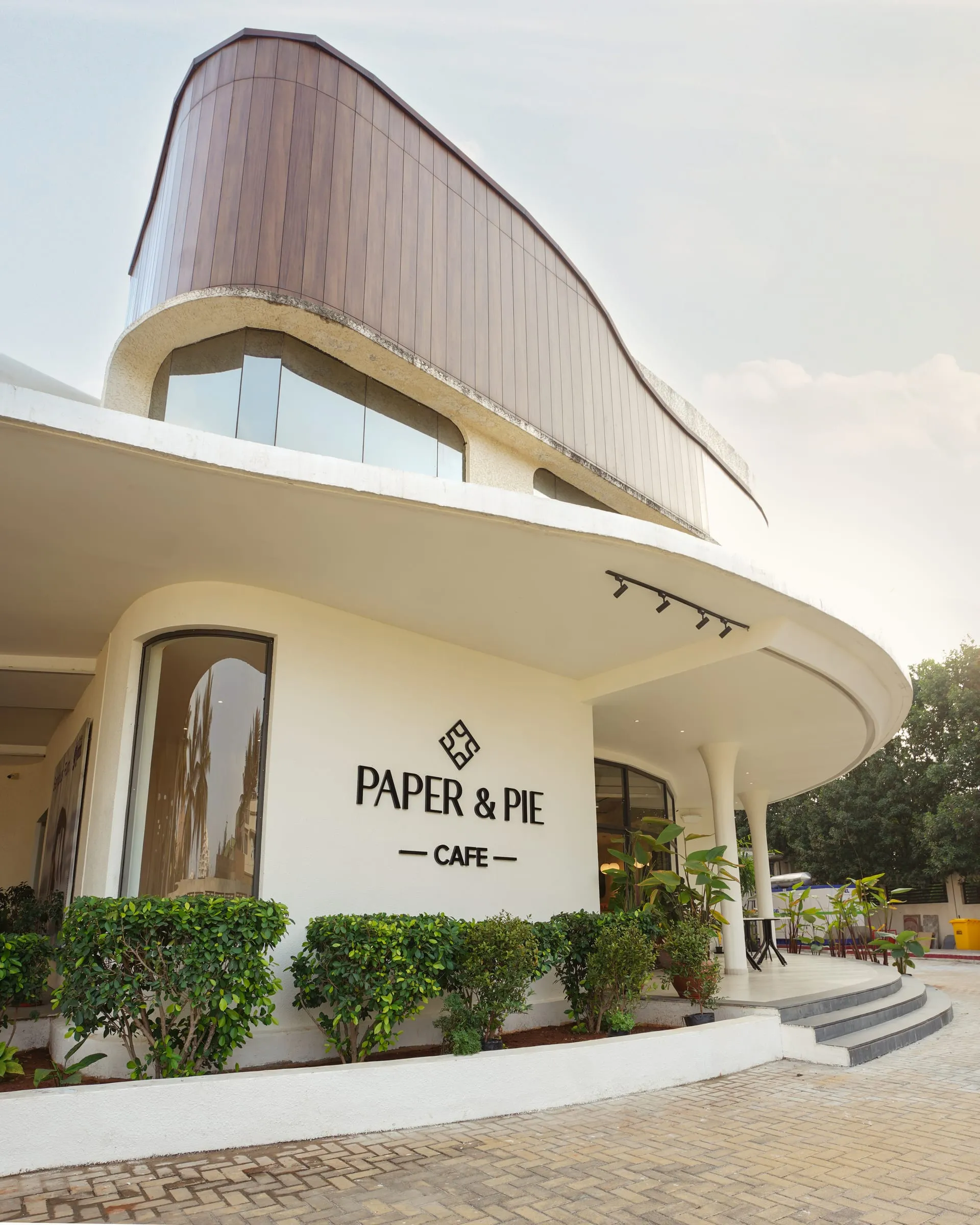 The curved white Paper & Pie café building in Whitefield